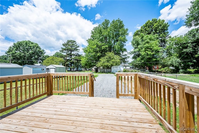 deck featuring a lawn and a storage unit