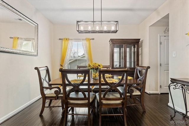 dining area with a notable chandelier and dark wood-type flooring