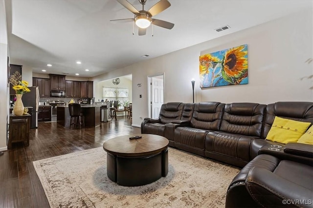 living room with dark hardwood / wood-style flooring and ceiling fan