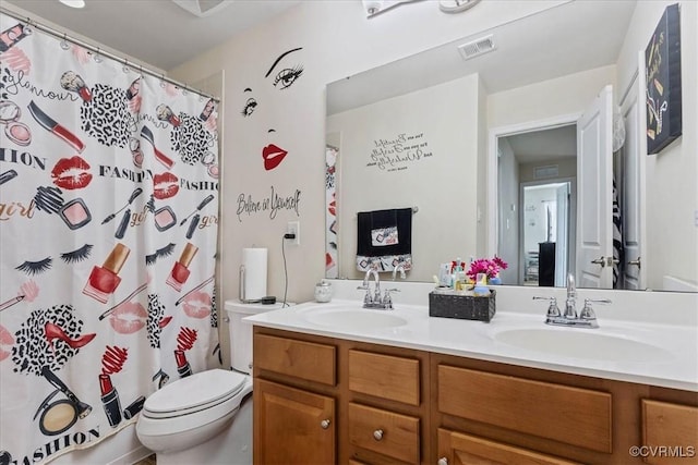 bathroom featuring vanity, toilet, and curtained shower