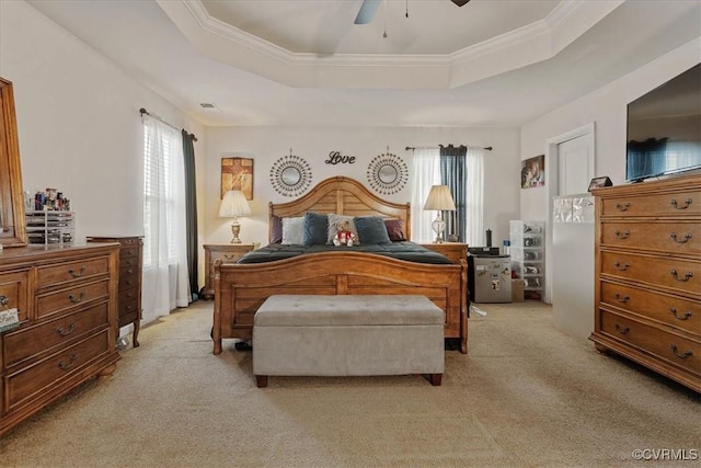 bedroom featuring multiple windows, ceiling fan, a raised ceiling, and light carpet