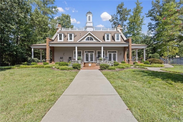 view of front of house featuring a front yard, french doors, and covered porch