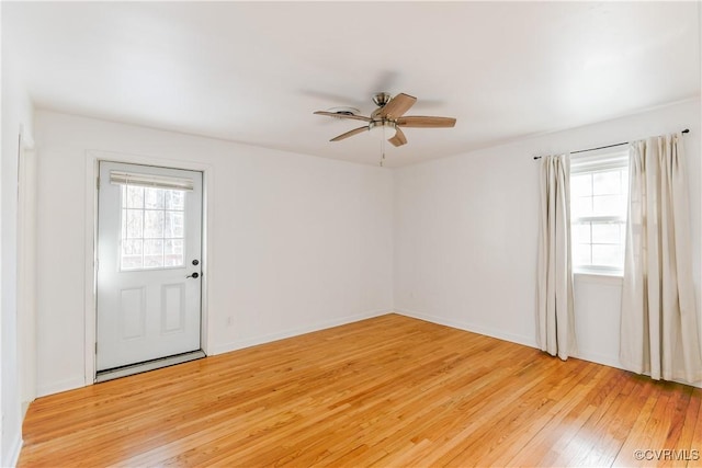 unfurnished room with ceiling fan, a healthy amount of sunlight, and light wood-type flooring