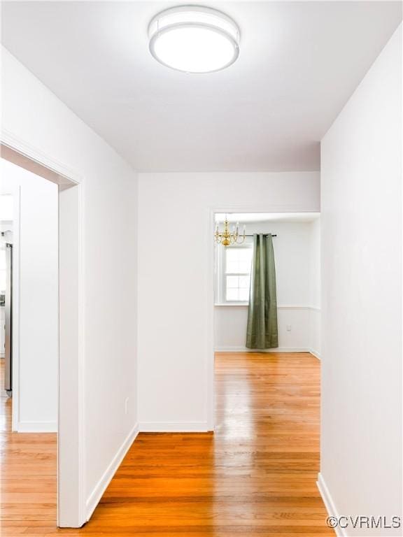 spare room featuring a notable chandelier and hardwood / wood-style floors