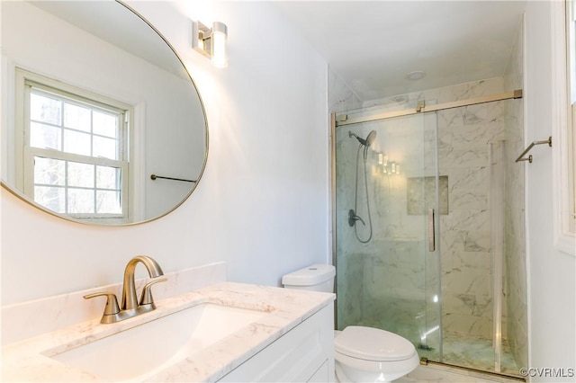 bathroom with toilet, a shower with shower door, and vanity