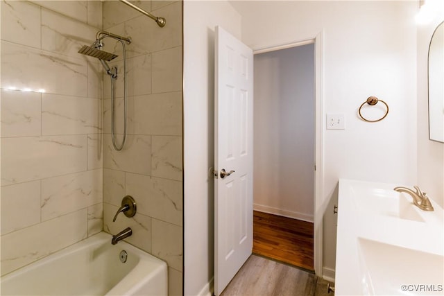 bathroom featuring wood-type flooring, vanity, and tiled shower / bath