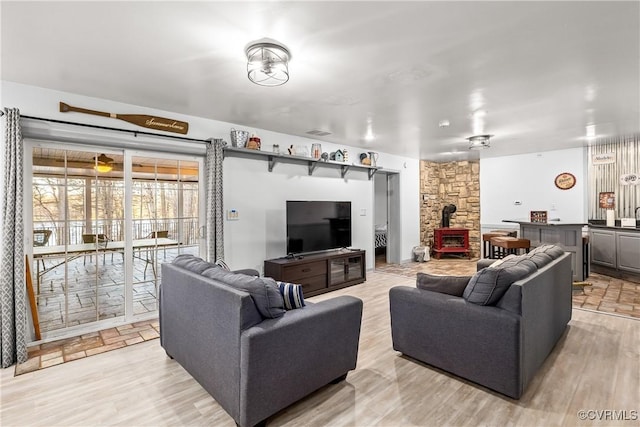 living room featuring light wood-type flooring and a wood stove