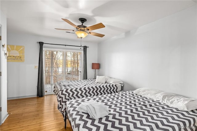 bedroom featuring access to exterior, light hardwood / wood-style floors, and ceiling fan