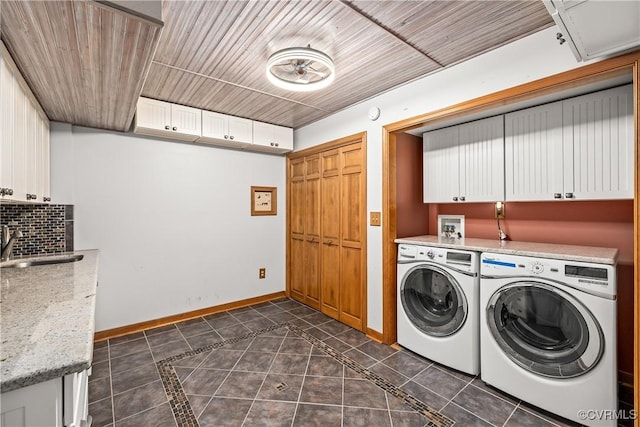 washroom featuring wood ceiling, cabinets, dark tile patterned flooring, and washing machine and clothes dryer