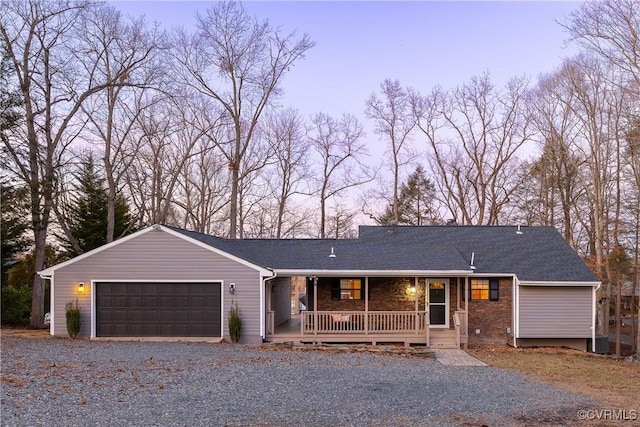 ranch-style house with a garage, central air condition unit, and covered porch