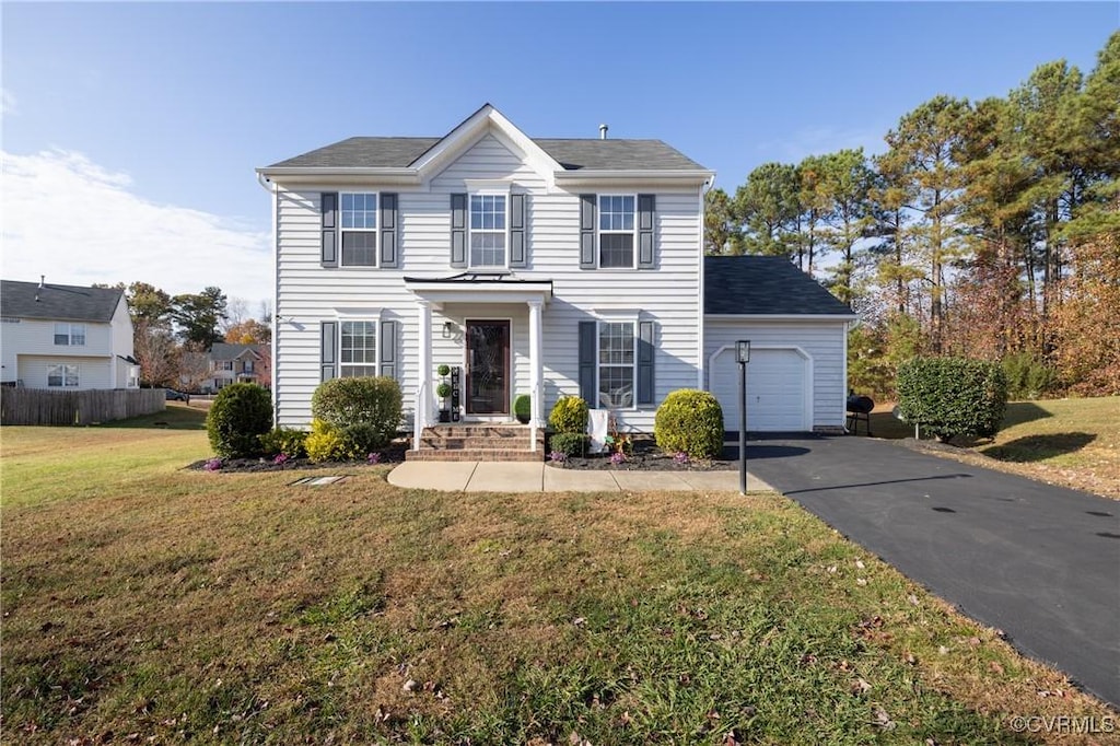 view of front of home with a front yard and a garage