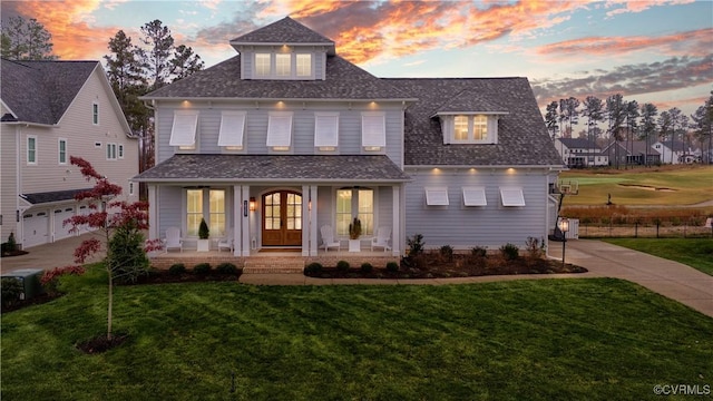 view of front facade featuring covered porch, french doors, and a lawn