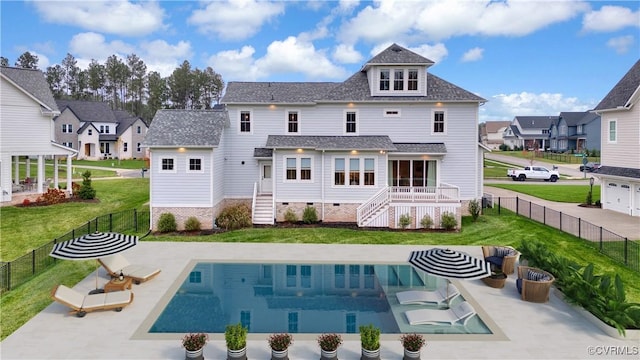 back of house featuring a fenced in pool, a lawn, and a patio