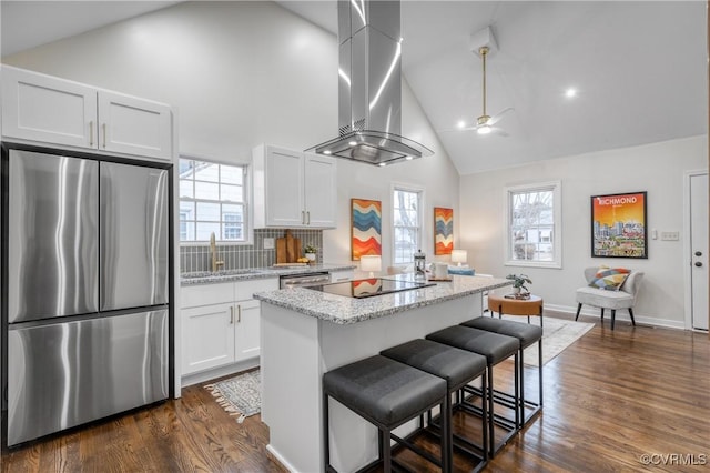 kitchen featuring ventilation hood, appliances with stainless steel finishes, white cabinetry, and light stone countertops