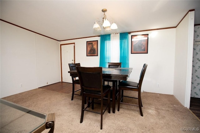 dining space featuring carpet, a notable chandelier, and ornamental molding