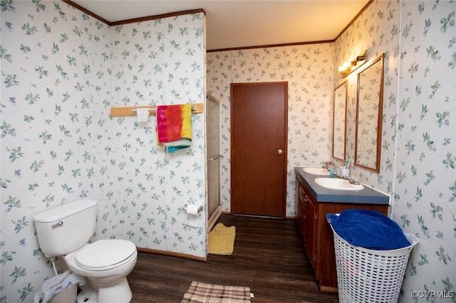 bathroom with hardwood / wood-style flooring, toilet, vanity, and crown molding