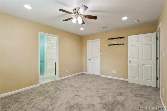 unfurnished bedroom with ensuite bathroom, ceiling fan, and light carpet