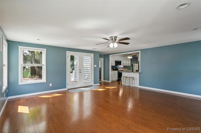 unfurnished living room featuring wood-type flooring and french doors