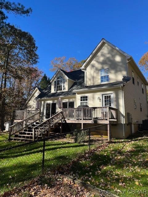 rear view of property with a deck and a lawn