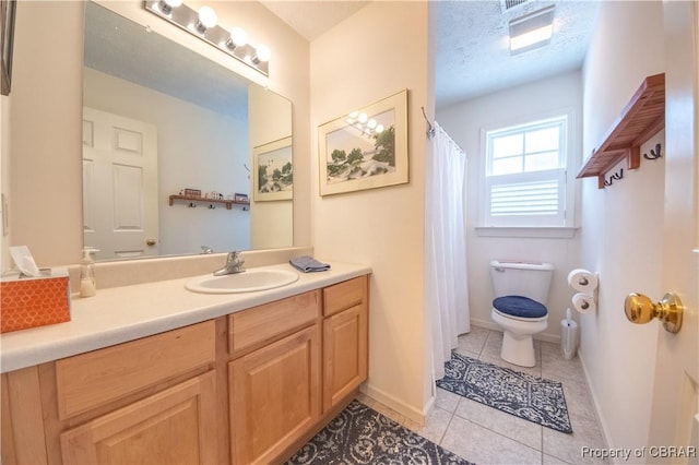 bathroom with vanity, toilet, tile patterned flooring, and a textured ceiling