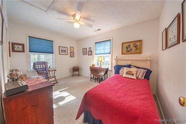 carpeted bedroom with ceiling fan and a textured ceiling