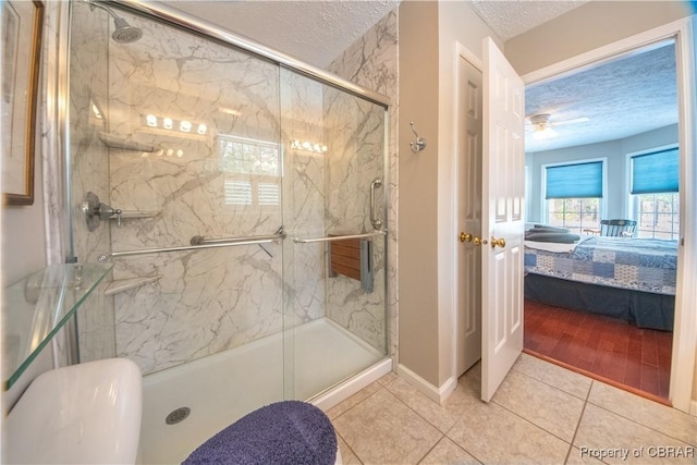 bathroom featuring an enclosed shower, tile patterned flooring, and a textured ceiling