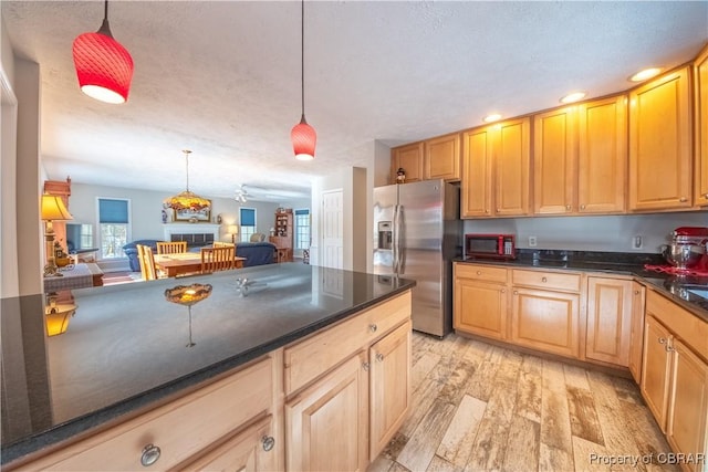 kitchen with pendant lighting, light hardwood / wood-style flooring, a textured ceiling, and stainless steel refrigerator with ice dispenser