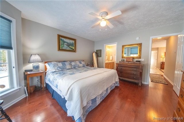 bedroom with dark hardwood / wood-style flooring, connected bathroom, a textured ceiling, and ceiling fan