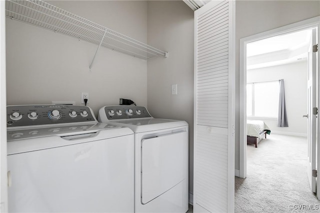 laundry area featuring light carpet and separate washer and dryer