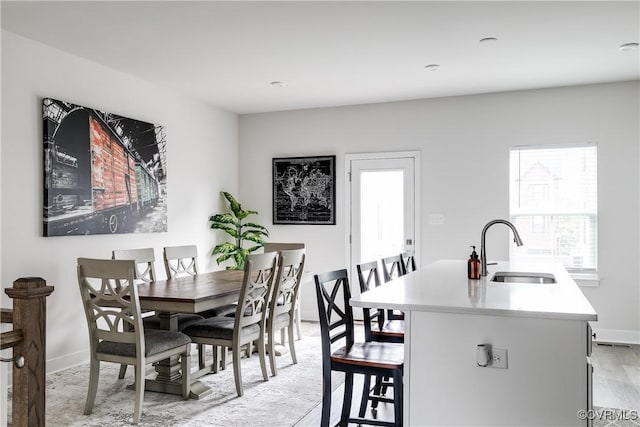 dining room with sink and light hardwood / wood-style flooring