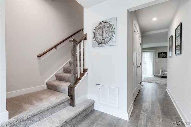 staircase with hardwood / wood-style flooring