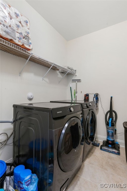 clothes washing area with light tile patterned flooring and washer and dryer