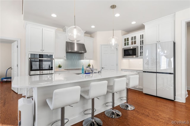 kitchen with white refrigerator, stainless steel oven, white cabinetry, and built in microwave