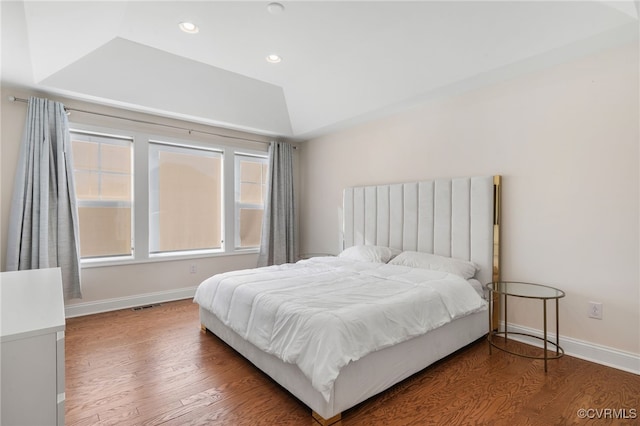 bedroom featuring hardwood / wood-style flooring and a raised ceiling