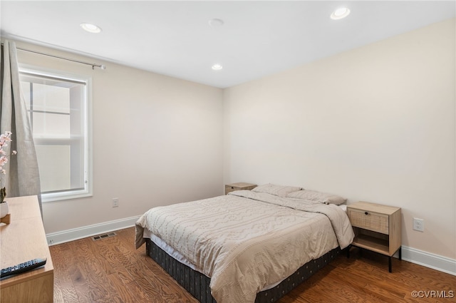 bedroom with dark hardwood / wood-style floors