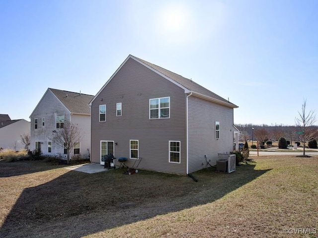 rear view of property with a yard, a patio, and central air condition unit