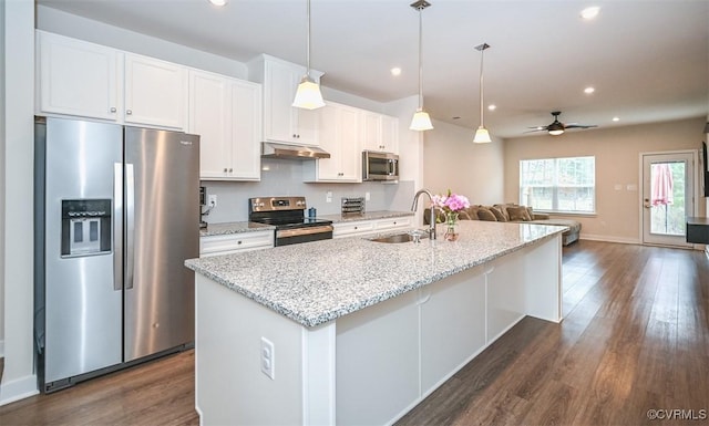 kitchen featuring sink, stainless steel appliances, white cabinets, and an island with sink