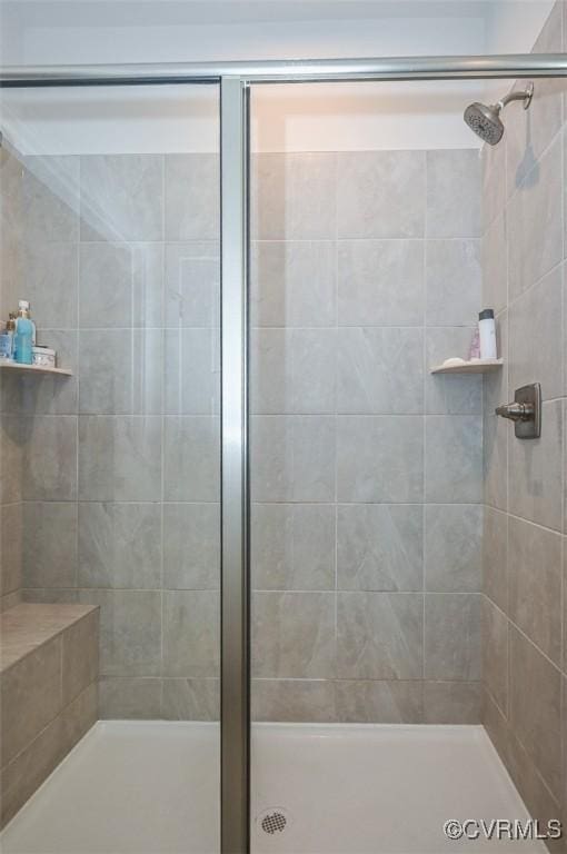 bathroom featuring a shower with shower door