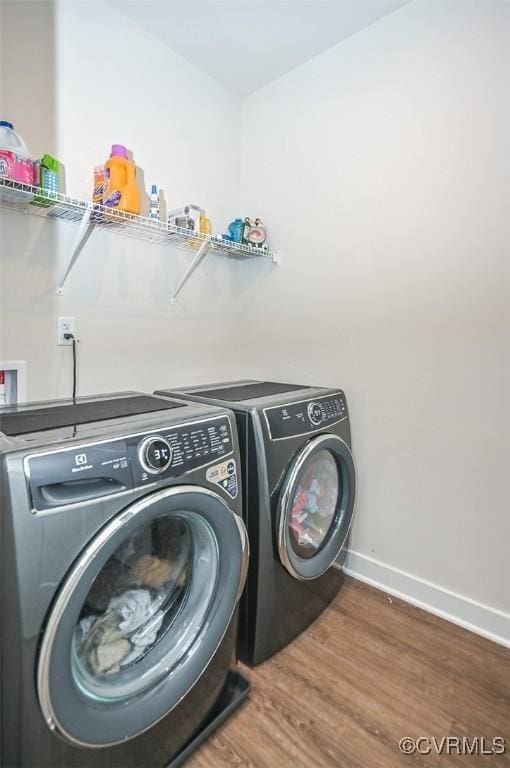 laundry room featuring hardwood / wood-style floors and washing machine and dryer