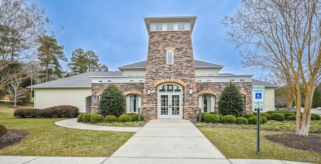 view of front of property featuring a front yard and french doors