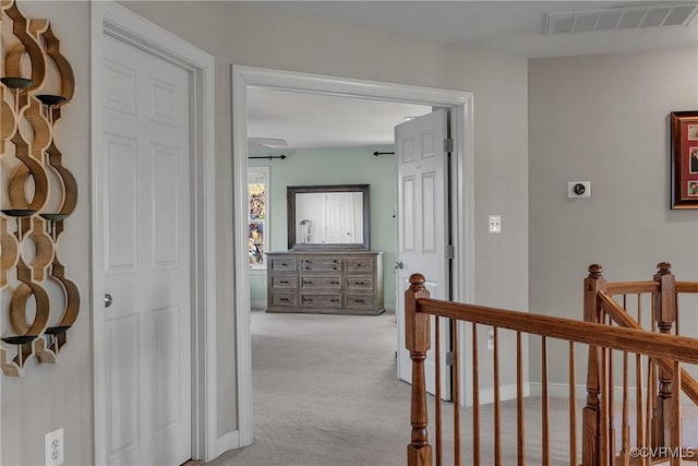 corridor featuring light colored carpet