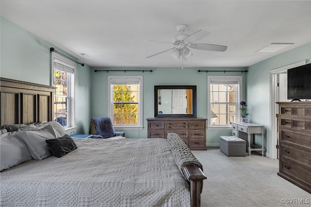 carpeted bedroom with multiple windows and ceiling fan