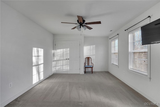 spare room with light colored carpet and ceiling fan