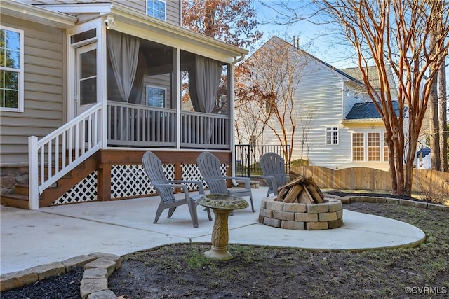 view of patio / terrace with a sunroom and a fire pit