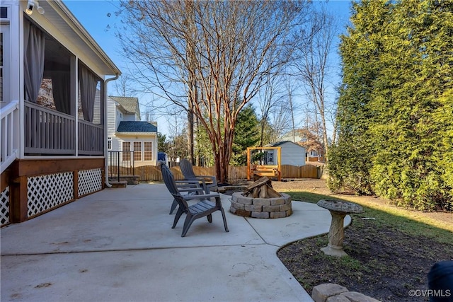 view of patio with a sunroom and a fire pit