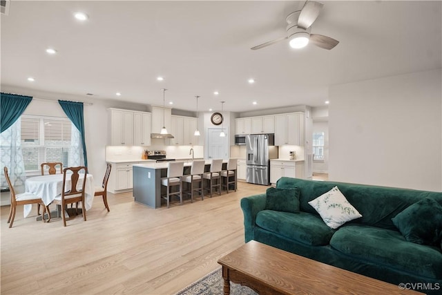 living room featuring light hardwood / wood-style flooring and ceiling fan