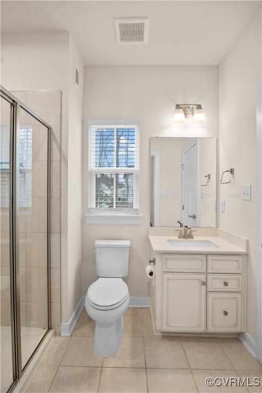 bathroom with toilet, tile patterned flooring, walk in shower, and vanity