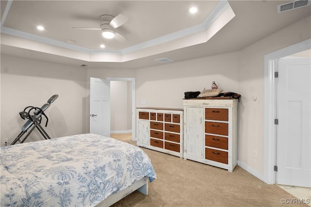 bedroom with ceiling fan, crown molding, light carpet, and a raised ceiling