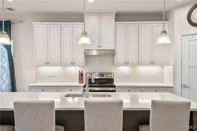 kitchen featuring sink, white cabinets, electric stove, a kitchen island with sink, and decorative backsplash