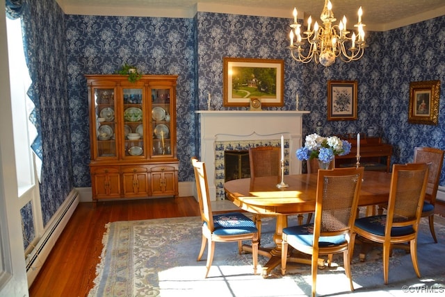 dining room with a chandelier, a healthy amount of sunlight, baseboard heating, and dark wood-type flooring